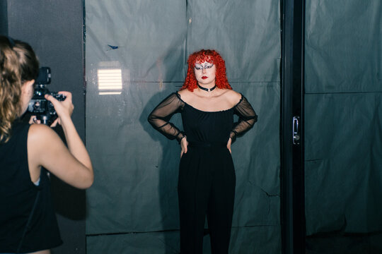 Gothic curly redhead poses while is recorded