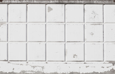 Concrete wall fence with white cracked paint. White wall surface with squares. Grunge wallpaper. Concrete wall texture with white cracked paint.