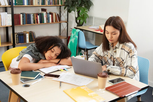 Multiracial students studying and sleeping in library