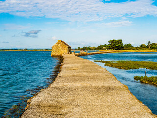 Amazing view of the tide mill and its dike at Arz Island in a bright sunny day, Morbihan gulf,...