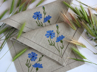 Linen napkins with cornflower embroidery and spikelets. Decorated table textile
