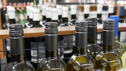 Close-up of many glass bottles of white wine in a wine shop