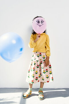 Stylish kid with balloon indoors