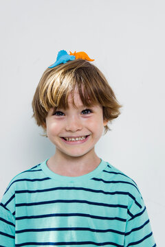 Cute boy with a dinosaurs on his head indoor