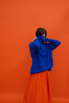 Faceless woman hiding in warm blue sweater 