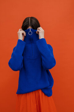 Faceless woman hiding in warm blue sweater 