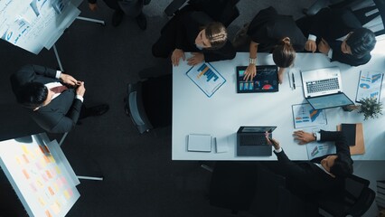 Top view of smart business people brainstorm marketing idea at meeting table while compare stock market investment data between laptop and tablet. Business team planning financial plan. Directorate.