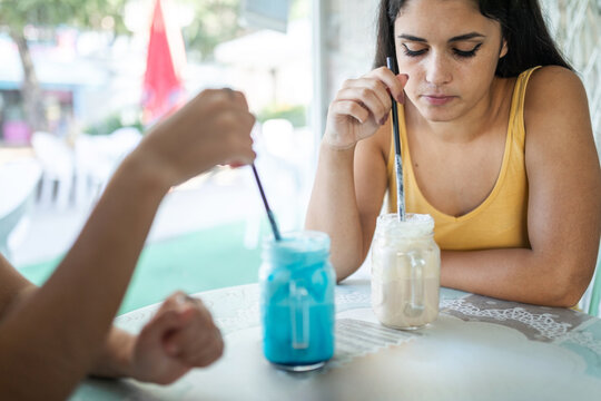 teenage friends having a milkshake in an ice cream parlor in the city