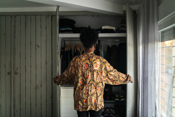 black woman at home arranging her closet