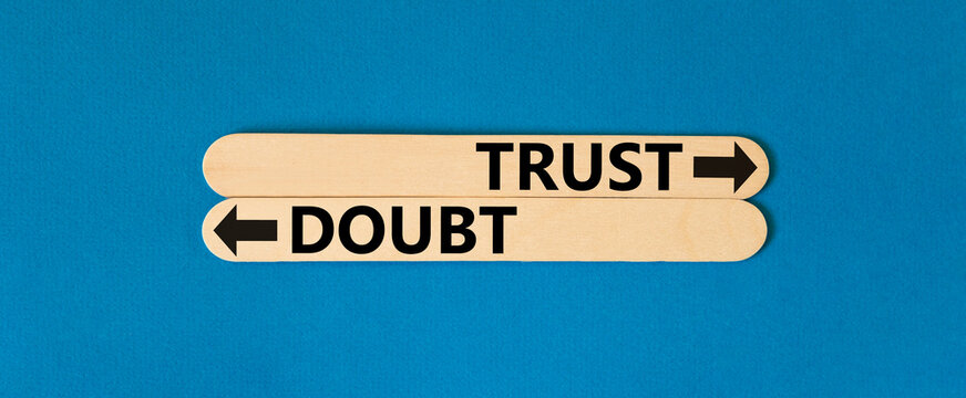 Trust or doubt symbol. Concept word Trust or Doubt on beautiful wooden stick. Beautiful blue table blue background. Business and trust or doubt concept. Copy space.