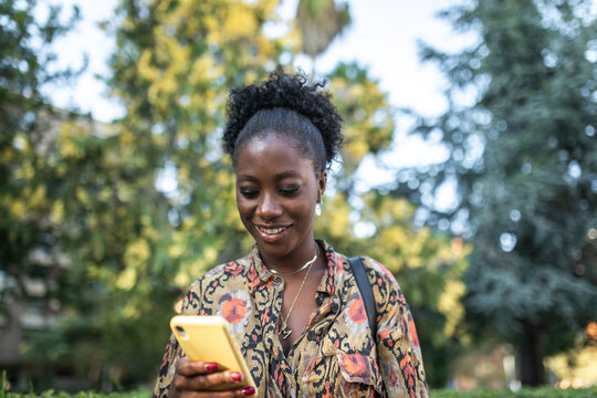black woman with mobile phone outdoors