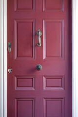 Fototapeta premium A close-up of a vibrant red door in New England, a bold focal point against the backdrop of traditional charm, encapsulating the region's inviting and picturesque aesthetic.