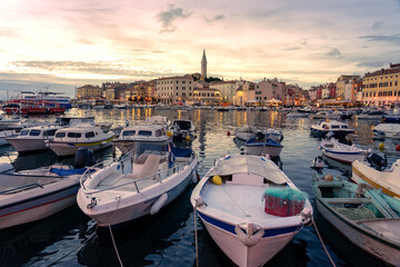 boats in the harbor in Rovinj in the evening with adriatic sea and sunset - obrazy, fototapety, plakaty
