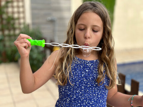 girl blowing bubbles