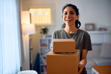 Happy Hispanic woman receiving home delivery and looking at camera.