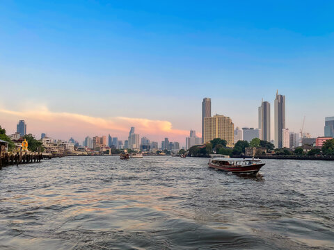 View of Bangkok's central business district from the Chao Phraya River at sunset. The river meanders south through the city and empties into the Gulf of Thailand