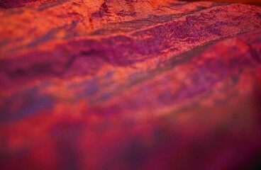 Abstraktes Motiv mit orange-lila gewelltem Stoff mit Muster als Hintergrund