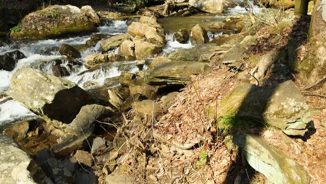 slow motion footage of the rushing waters of Smith Creek and waterfall at Anna Ruby Falls with rocks and lush green trees and plants in Helen Georgia USA