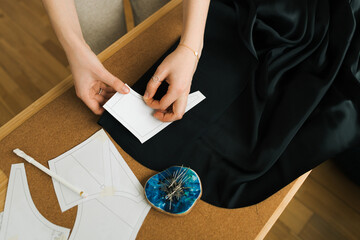 Female hands pinning pattern to fabric