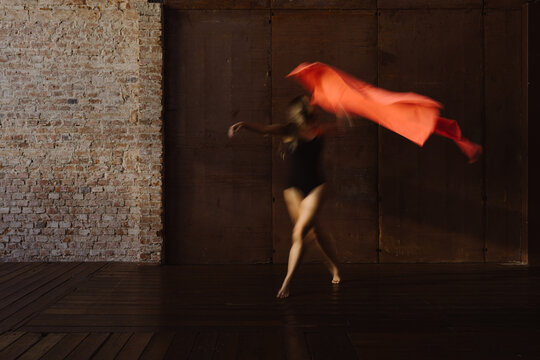 Woman dancing with an elastic salmon fabric
