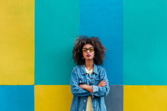 Smiling Egyptian woman with crossed arms on colorful background