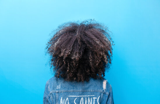 Curly haired woman in casual outfit backside portrait