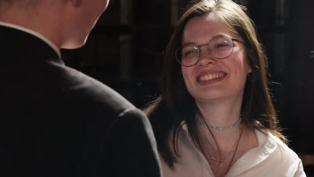 Young lady with magnificent smile enjoys conversation in pub. Romantic couple talks on date spending leisure time together