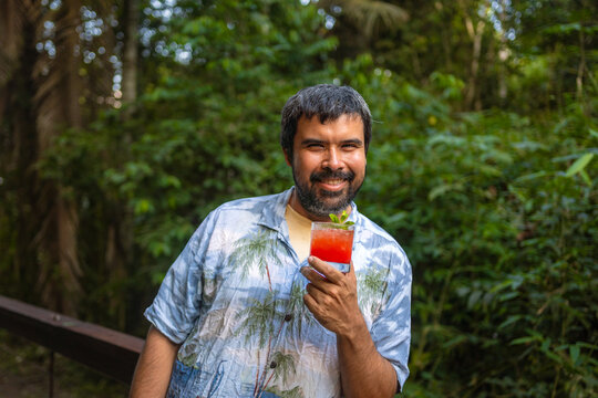 Bartender with colorful drink smiling in nature
