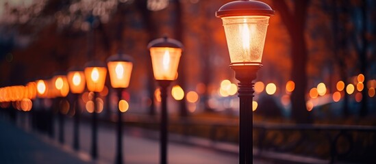 This photograph shows a row of street lamps powered by solar energy lined up closely together. The selective focus creates a soft glow around the lamps, highlighting their design.