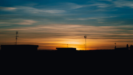 Obraz premium Beautiful sunset in a city, with incredible clouds, architecture of buildings against light
