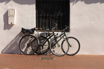 Two bicycles in front of a wall. Healthy mode of transportation. Without pollution. Horizontal. stone wall background. texture. sunlight