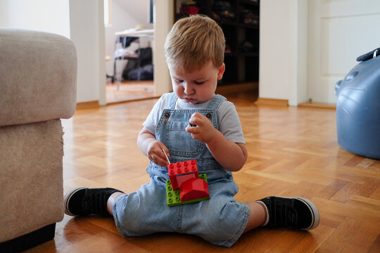 One year old boy sitting on the floor and playing with toys