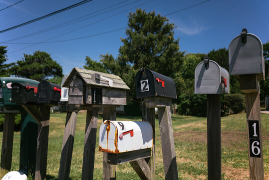 Assorted post boxes on wooden fence in countryside
