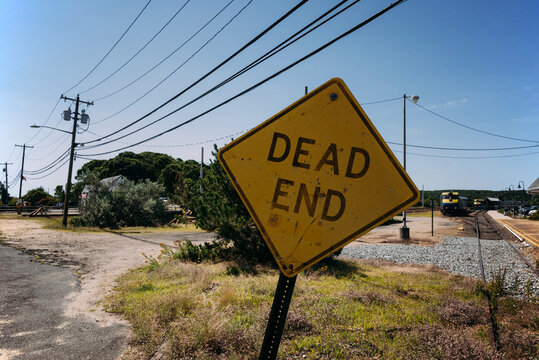 Dead End road sign near railway station in countryside
