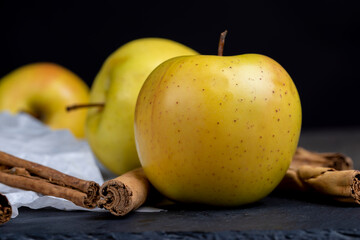 yellow ripe apple with cinnamon on the table