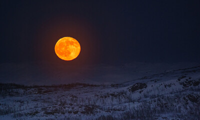 full moon over snow covered landscape during evening