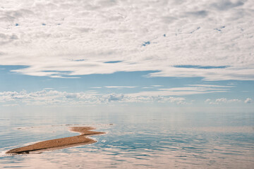 Beautiful seascape with sky reflected in the water and strip of land - 753883978