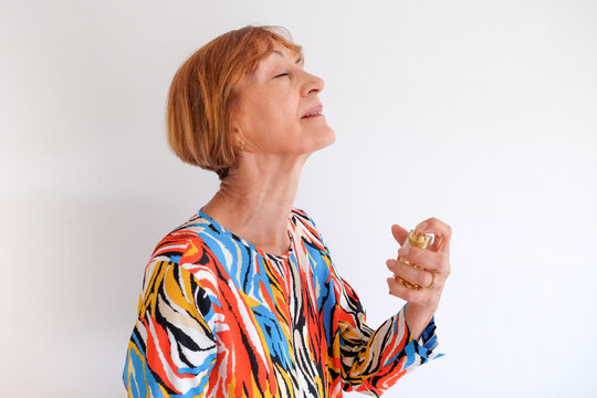An adult woman putting on a perfume