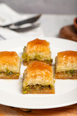 Pistachio baklava. Turkish and Arabic cuisine delicacies. Baklava on a wooden serving plate. Close up