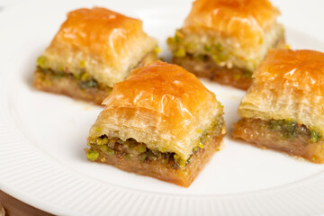 Pistachio baklava. Turkish and Arabic cuisine delicacies. Baklava on a wooden serving plate. Close up