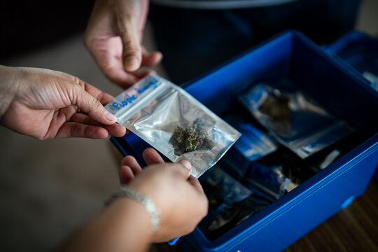 Someone buys homegrown marijuana at a street food vendor in Thailand