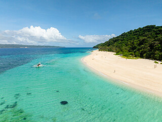 Beach with coconut trees and ocean waves on white sand. Puka Shell Beach. Boracay Island. Philippines.