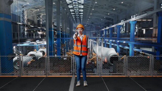 Full Body Of Asian Female Engineer With Safety Helmet Disapproving With No Index Finger Sign While Standing In Factory Manufacture Of Wind Turbines 