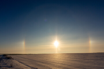 Winter landscape with circular halo phenomena around the sun