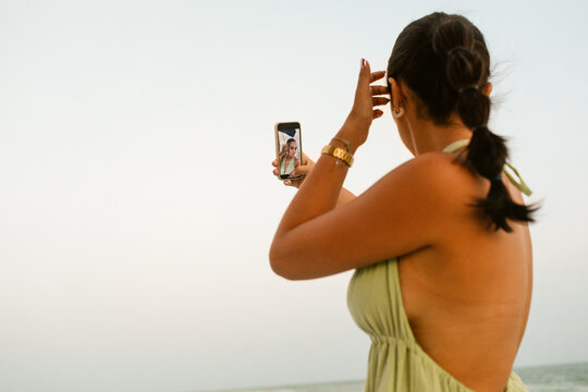Woman looking at phone by the Sea