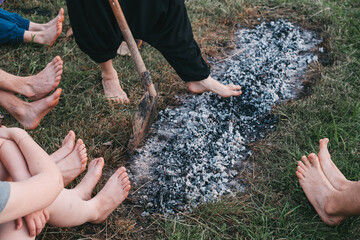 Coal walking or fire walking. Barefoot person on burned wood and hot embers. Training willpower and...