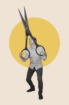 A man holding giant scissors