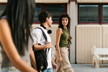Happy college students talking while walking on street
