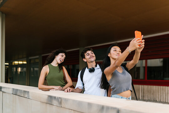 Cheerful diverse friendly classmates taking selfie