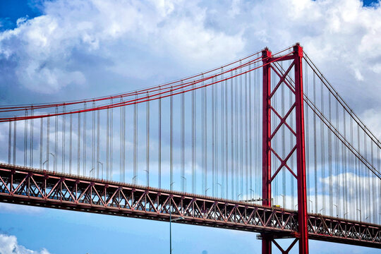 double-decker road-rail suspension bridge, Lisbon landscape Panoramic photo of the April 25 Bridge in Lisbon over the Tajo River against the blue sky
